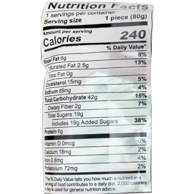 Each serving of this cake (80g) contains 240 calories, with a total fat content of 6g, including 2.5g of saturated fat and 0g of trans fat. The cholesterol content is 15mg, sodium is 85mg, and total carbohydrates are 42g, which includes 2g of dietary fiber and 19g of total sugars. It provides 6g of protein, along with small amounts of calcium, iron, and potassium.