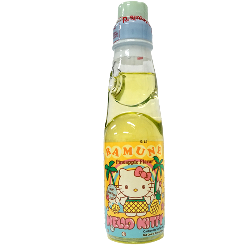 Front view of bottle. The soda comes in a charming, clear bottle featuring a playful design with Hello Kitty dressed in a pineapple-themed outfit, set against a backdrop of tropical elements like palm trees and seashells. The vibrant yellow liquid inside adds to the tropical allure, making it as visually appealing as it is tasty.